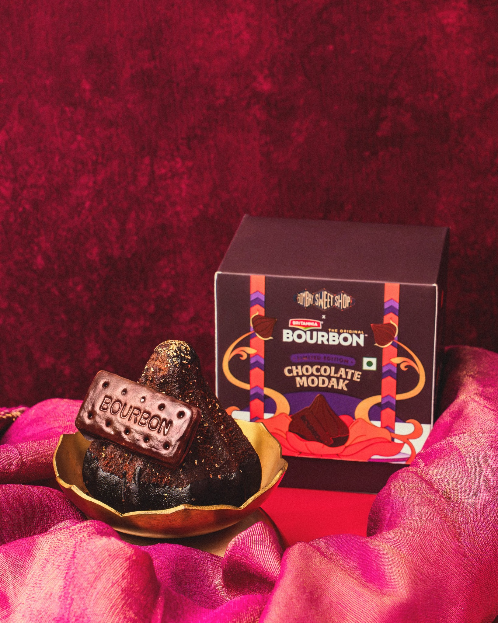 Bourbon Chocolate Modak on a gold plate alongside its Bombay Sweet Shop gift box