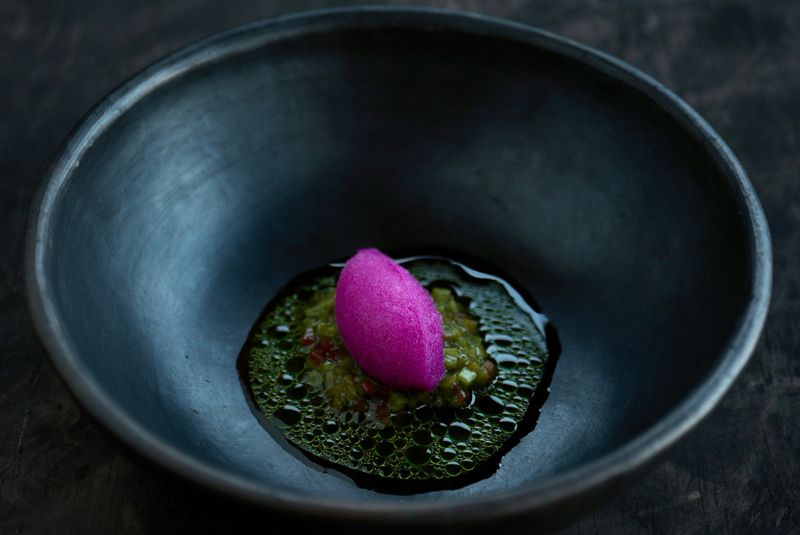 A vivid pink plated dish in a dark bowl at Naar