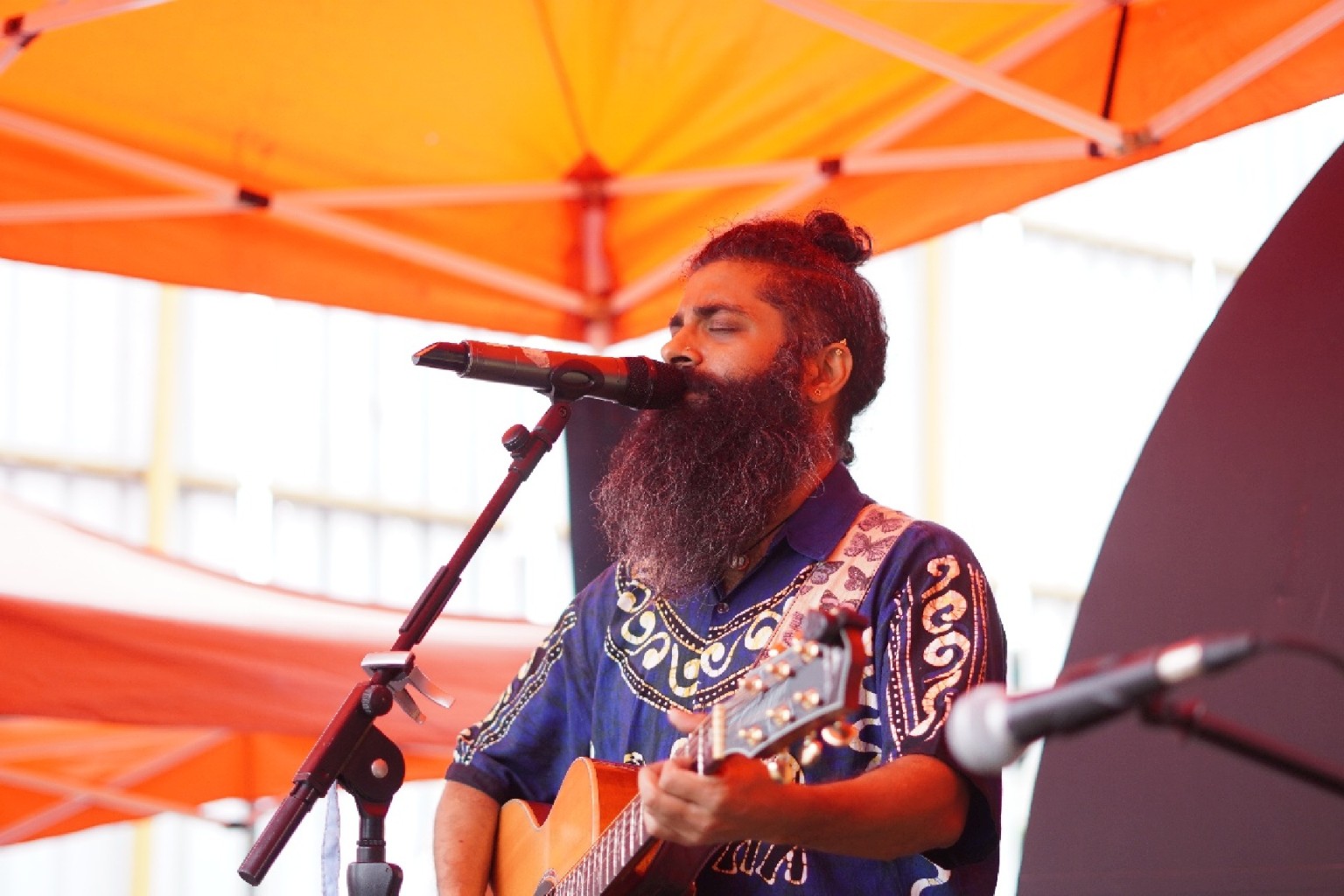 A singer with an acoustic guitar at an earlier busking performance
