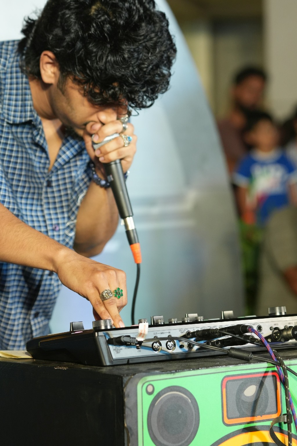 A musician singing while working with live electronic equipment