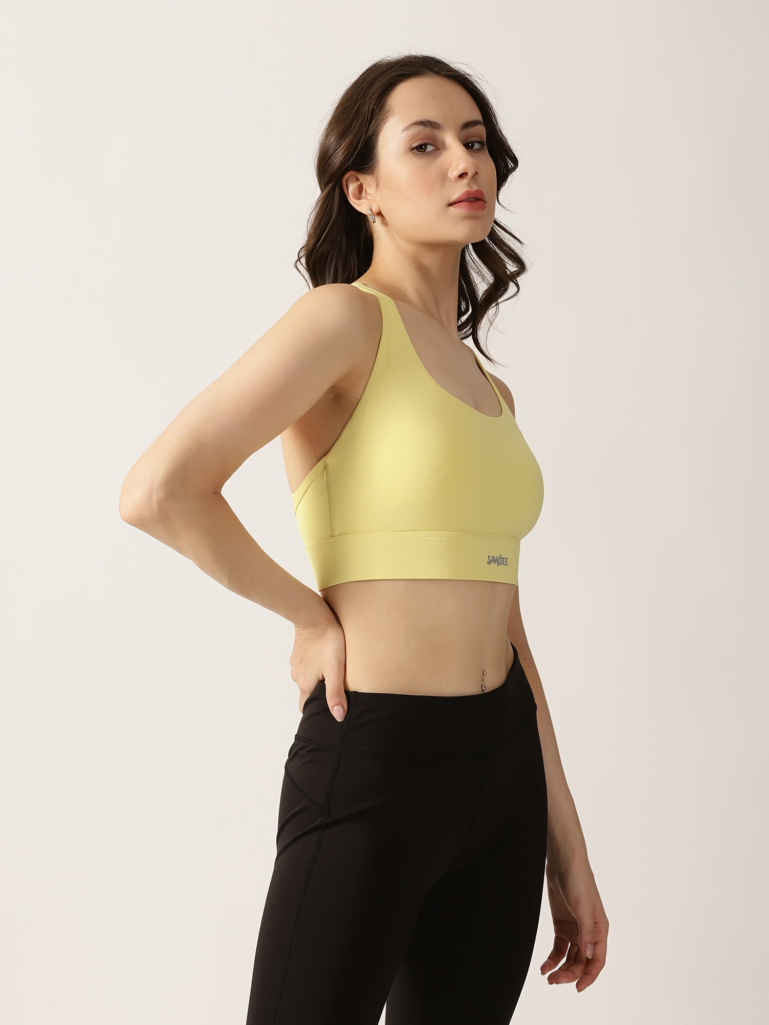 Sawsee PlayDate Flow Sports Bra in Butter Yellow paired with black leggings.